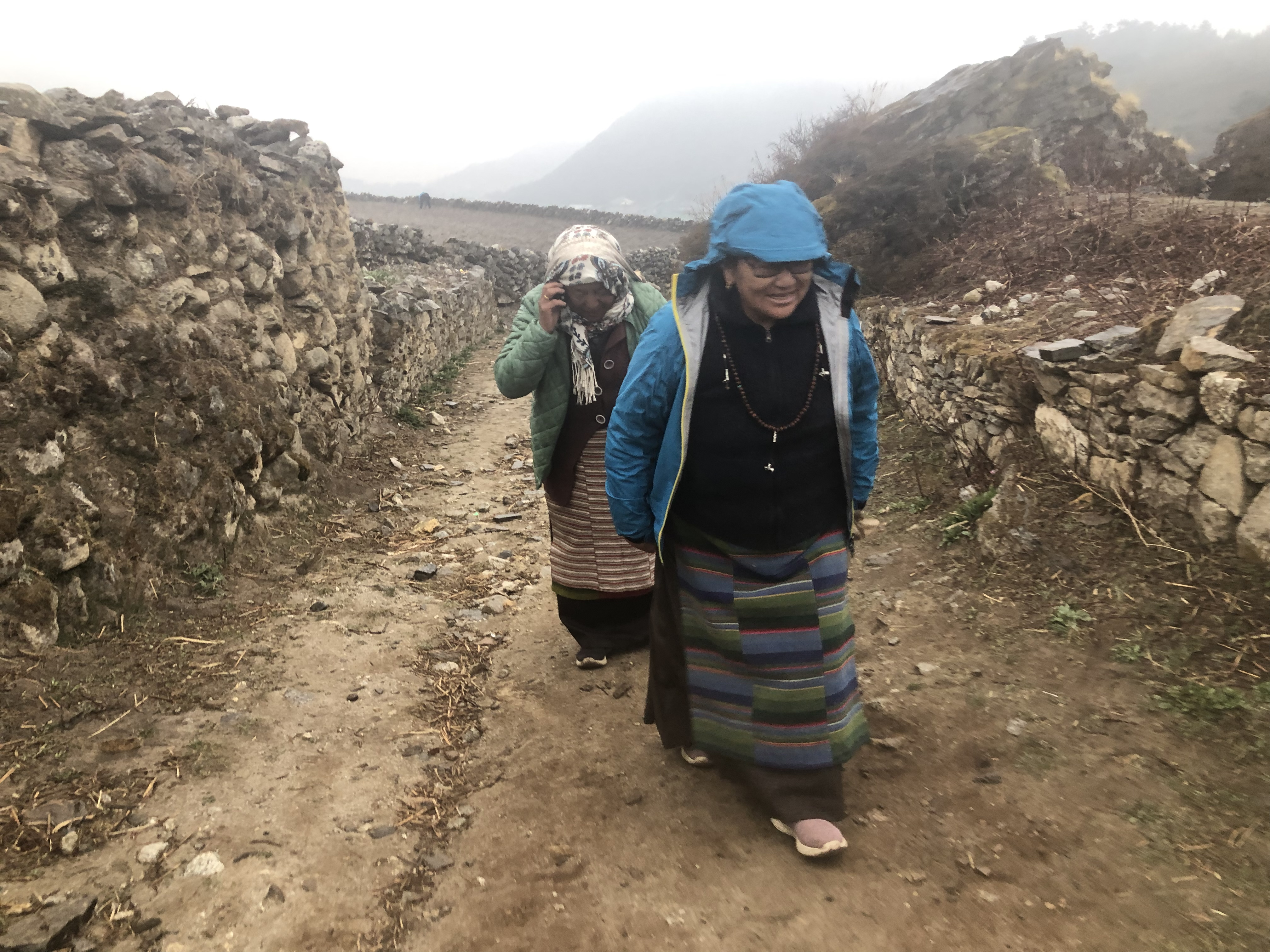 Ang Pashang Sherpa walking home with a friend in Khumjung.She is worried about the condition of her farmland’s soil because she feels like it is changing but she feels like there is nothing she can do.