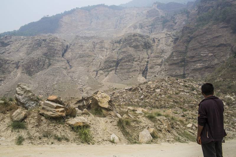 A man waits for bus on the debris of Jure Landslide in Bhotekoshi River that occured on 2014. Sindhupalchok, Nepal