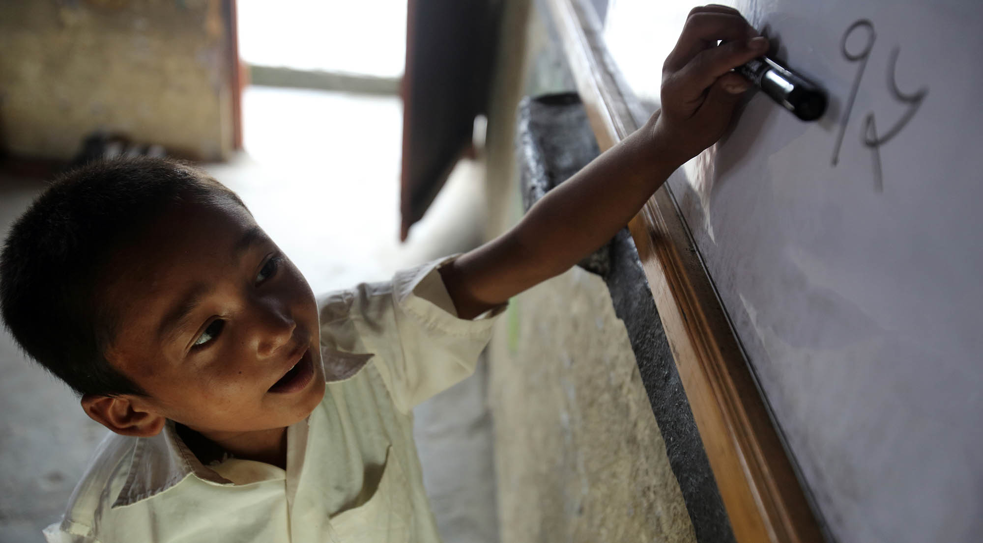 Unnamed boy working from the blackboard at Shree Sahara Bal Primary School, Pokhara , grade1, Pokhara, Nepal.