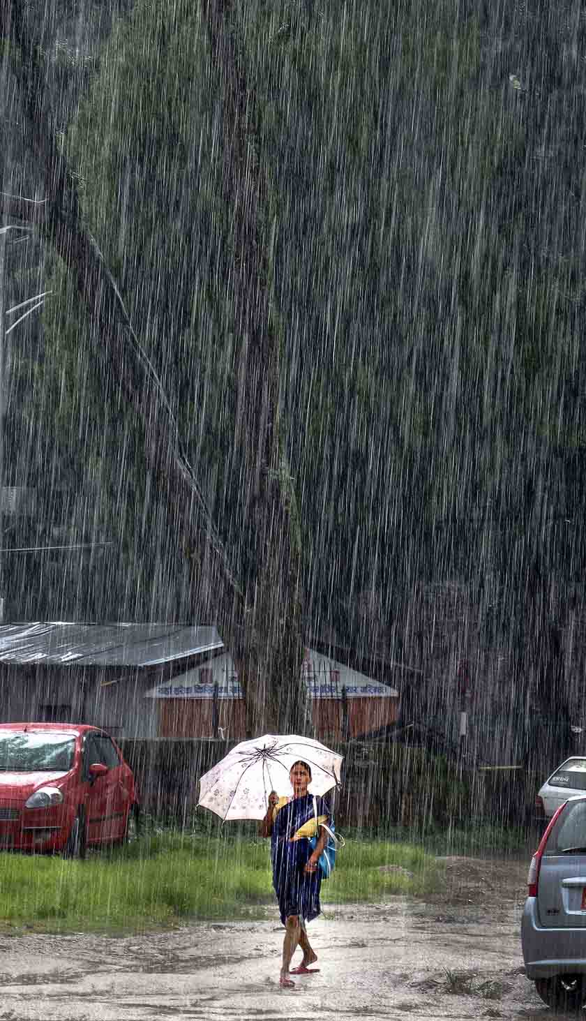 A woman walks towards her destination in the monsoon rain near the Pashupatinath Temple. During monsoon, Kathmandu receives 48.4 mm rainfall on average.