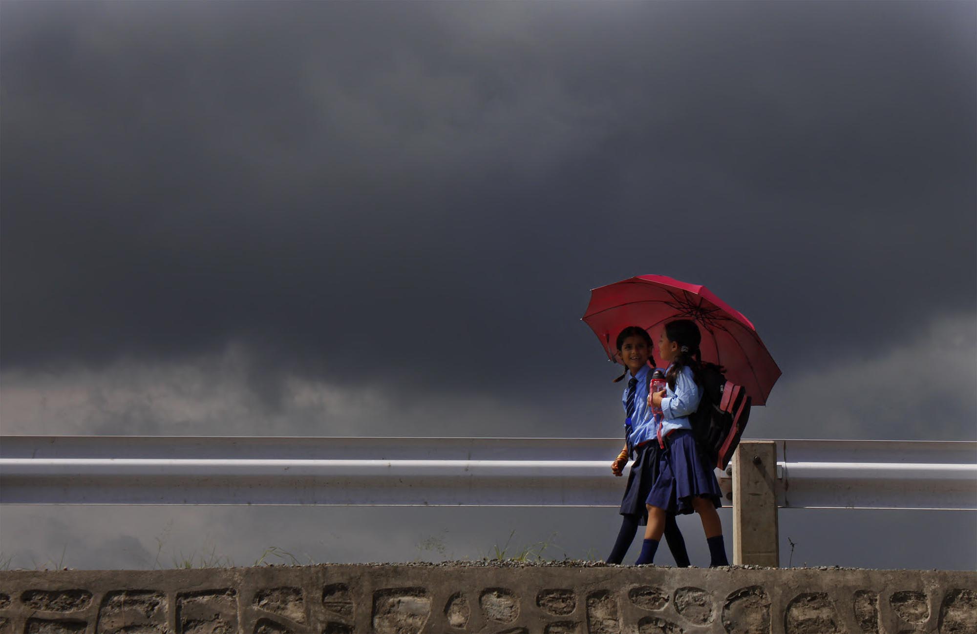School children return from school to home with umbrella at Koteswor, Bhaktapur on wednesday. POST PHOTO: PRAKASH CHANDRA TIMILSENA/KANTIPUR.