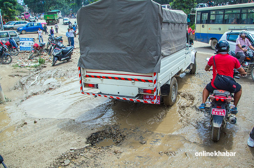 File Image: Road potholes full of rainwater