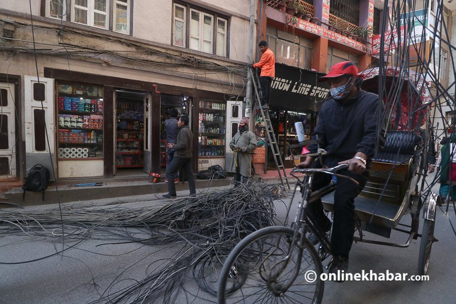 File: Wires being removed from poles in Thamel of Kathmandu