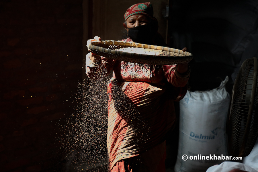 A woman separating hays from mustard seeds