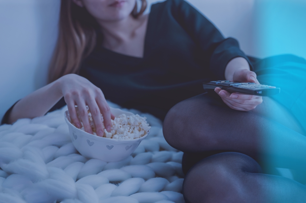 woman watching movie eating popcorn