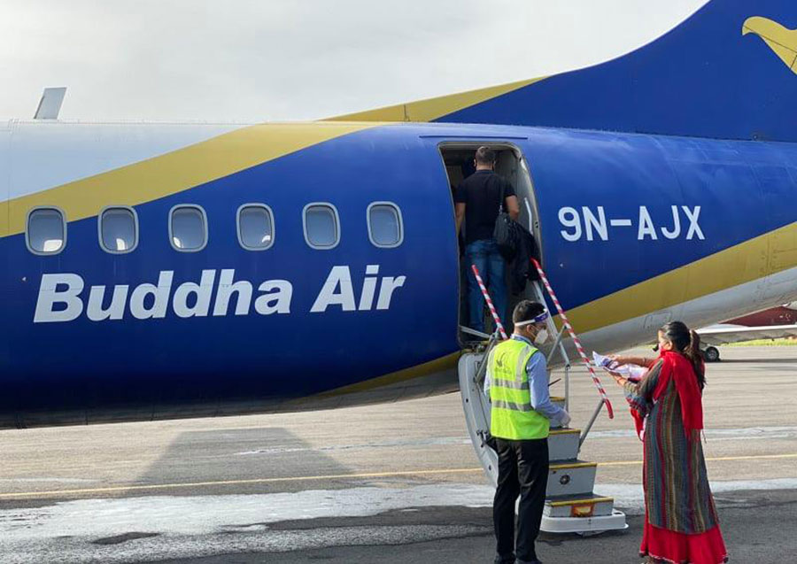A passenger boards a flight at Kathmandu-based Tribhuvan International Airport as the domestic flight service resumes after six months, on Monday, September 21, 2020. Photo: Courtesy Buddha Air