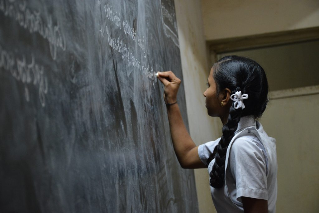 young girl writing in class