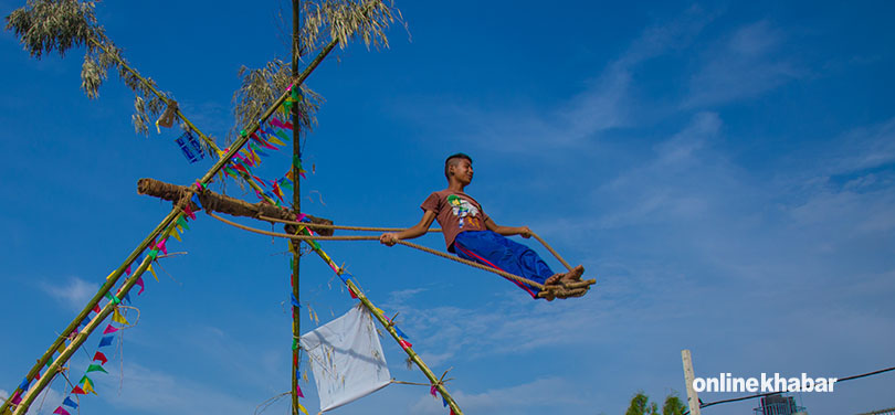 File: A child swings on a linge ping. dashain songs play in the background