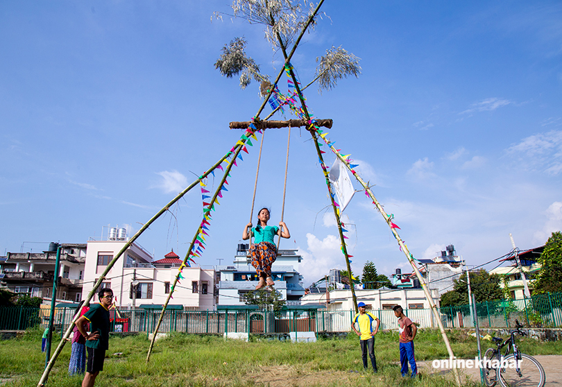 File: People play on a swing as it symbolises the Dashain celebration in Nepal.
