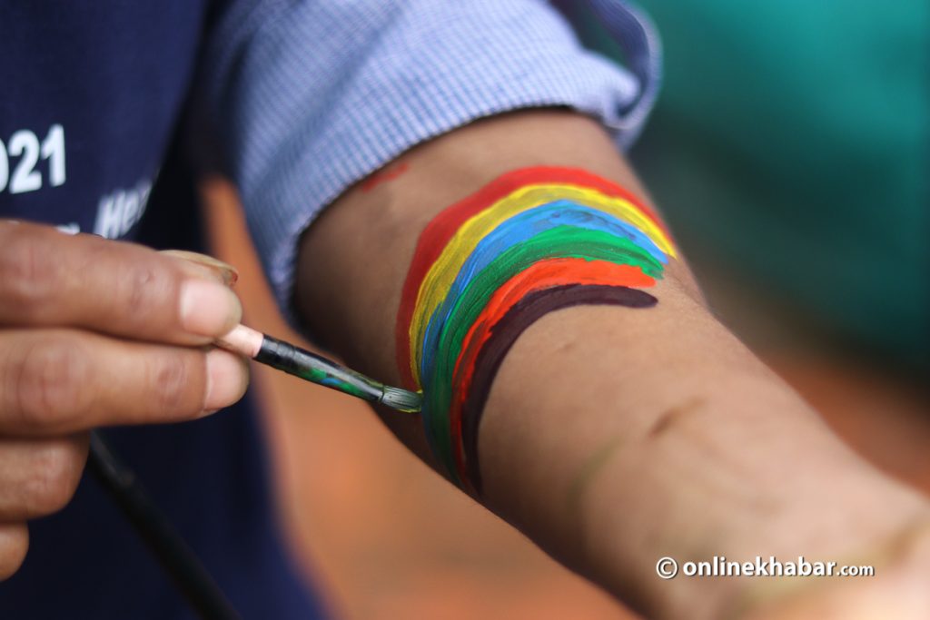 A member of a sexual minority group paints rainbow on a hand, during the Gai Jatra celebration, in Kathmandu, on Monday, August 23, 2021. Photo: Aryan Dhimal
