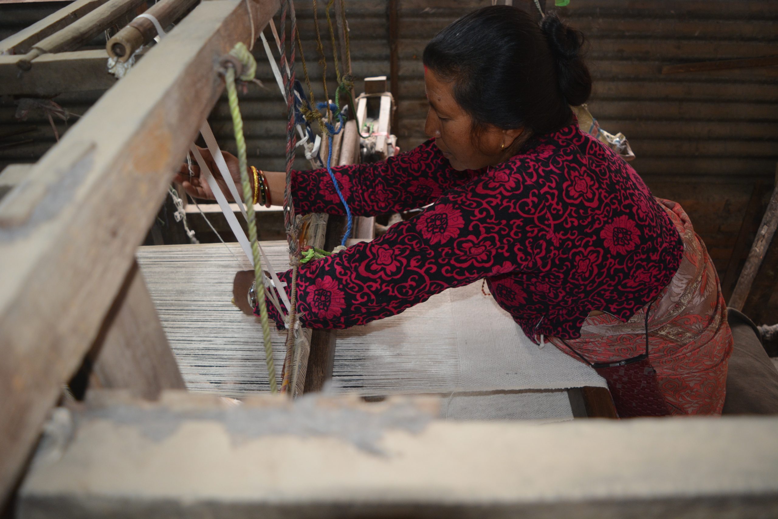 A woman works with her handloom to weave cloth. Photo: Didi-Bahini Creations