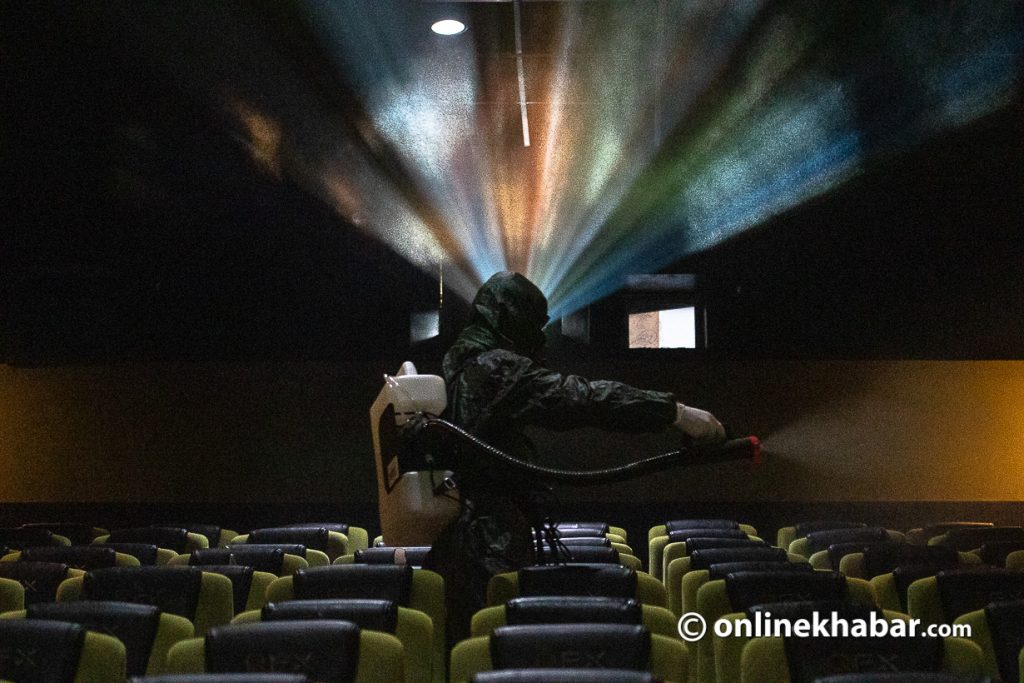 A staffer disinfects a movie theatre in Kathmandu in the wake of the Covid pandemic. Photo: Aryan Dhimal