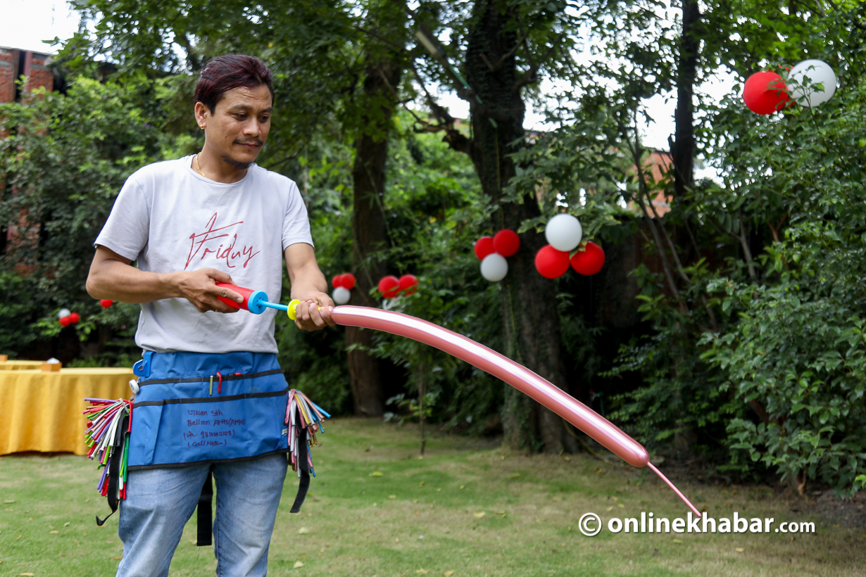 Jivan Shrestha in action, inflating balloons in an event in Kathmandu.
