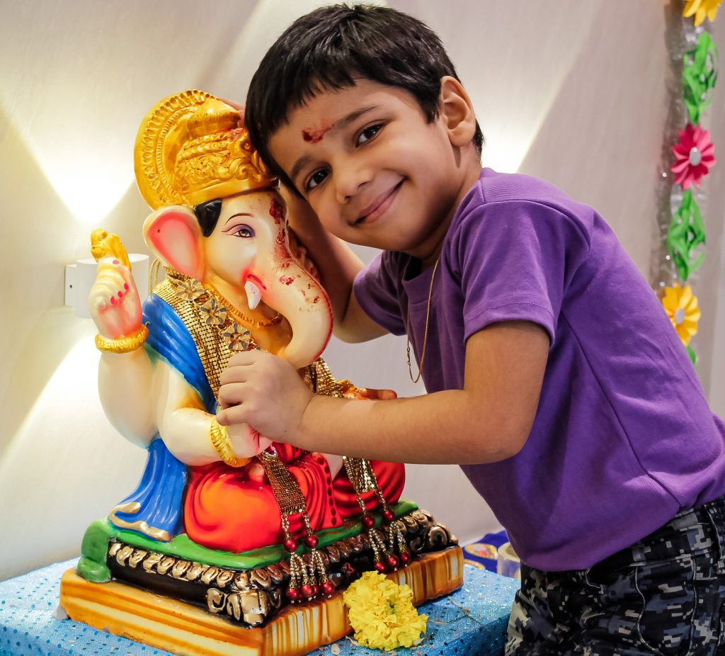 A child with a Lord Ganesha idol