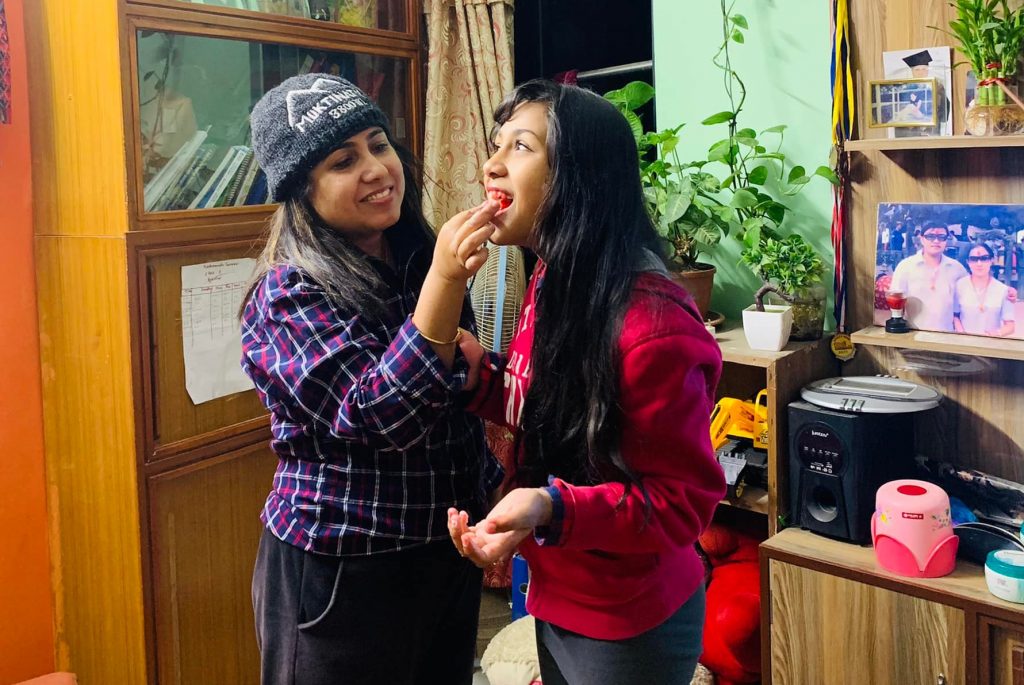 Namita feeding a slice of cake to her daughter, Sharon, as she has her first period. Photo: Courtesy Namita Poudel