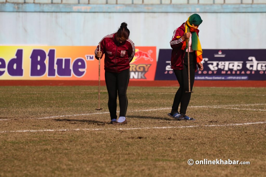 Dasharath Stadium ground staff patching up the ground at half time during a match. Photo: Bikash Shrestha