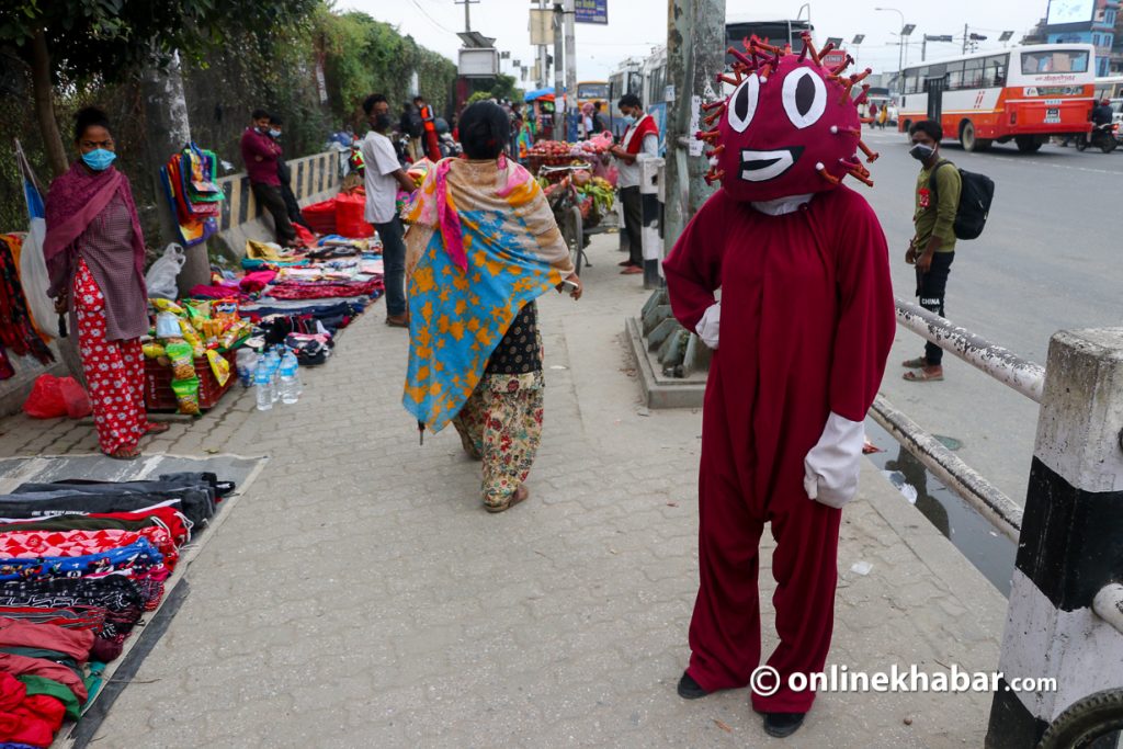 A person dressed as coronavirus raising awareness at a bus station in Kathmandu.