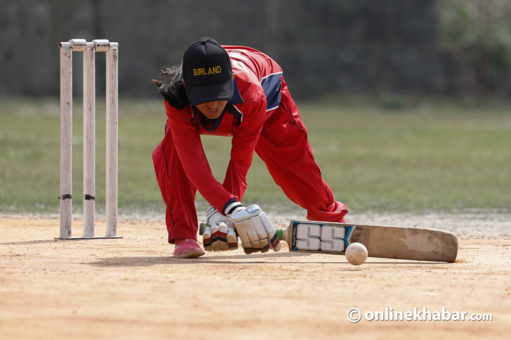 A blind women cricketer hits a ball during a match. 