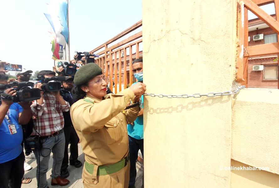 A security staffer of the Pashupati Area Development Trust padlocks the the Hotel Anand, a hotel operated by Batas Group at a property owned by the trust, in Kathmandu, on Friday, April 8, 2022.