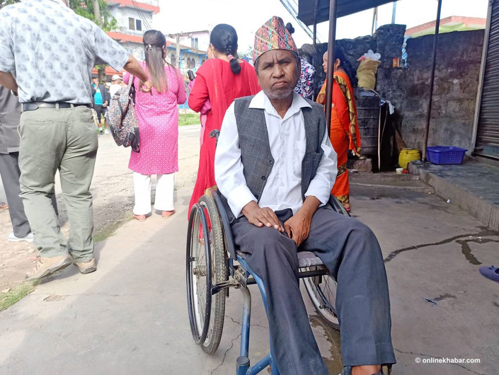 A wheelchair-bound man goes to cast his votes during the local elections in Nepal, on Friday, May 13, 2022. 