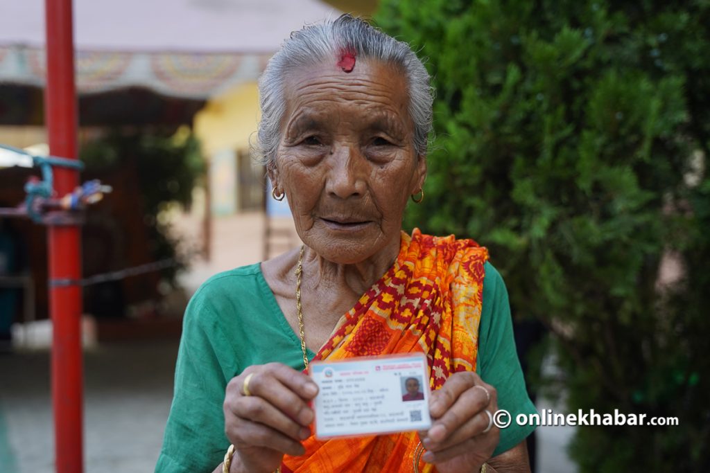 File: A woman shows her voter id card before voting