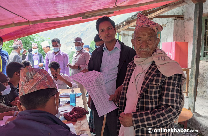 An elderly man prepares to cast his votes during the local elections, in Mugu of Karnali, on Friday, May 13, 2022.