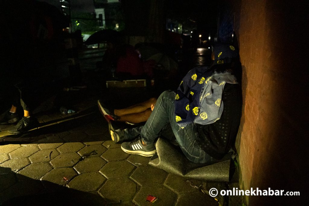 Service seekers waiting for their national ID cards sleep on the roadside. Photo: Aryan Dhimal