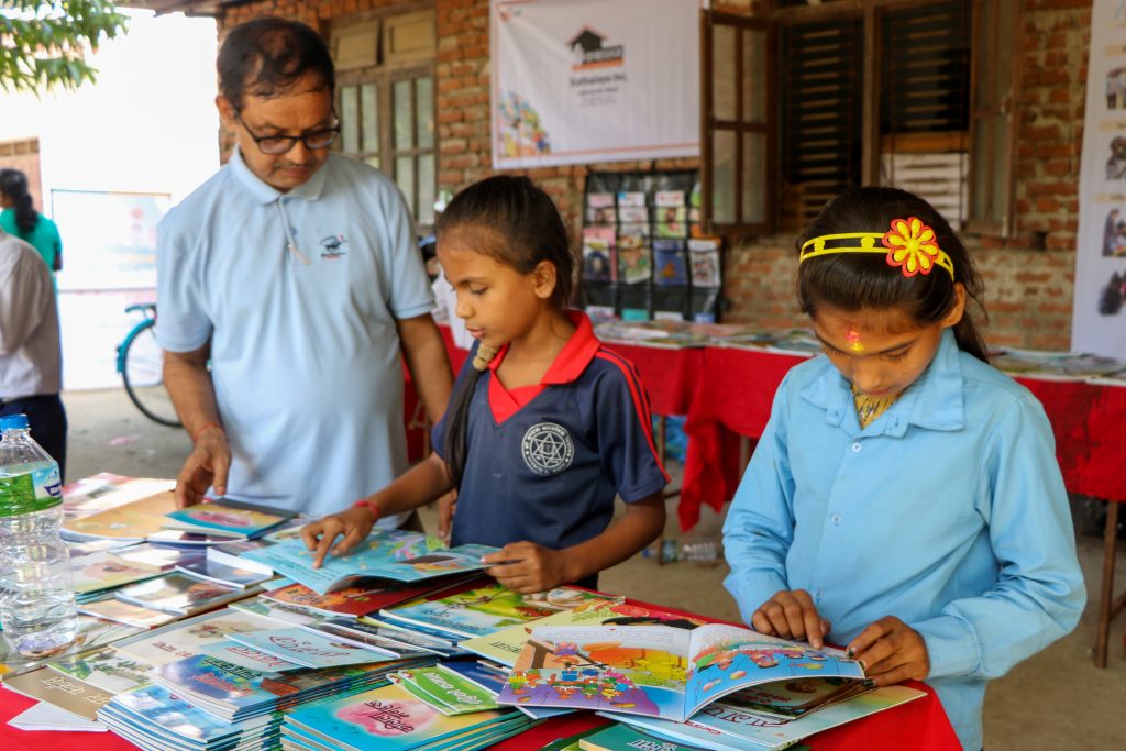 Children reading storybook in the open library section during Children's Literature Festival.