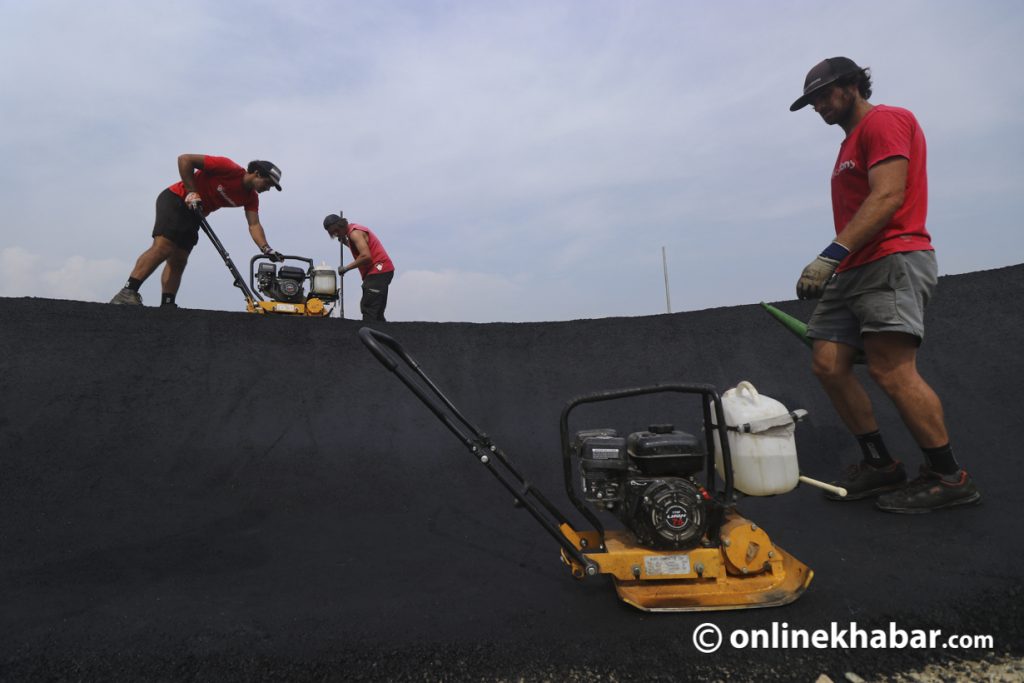 Team members of Velosolutions level the asphalt on the pump track. Photo: Aryan Dhimal