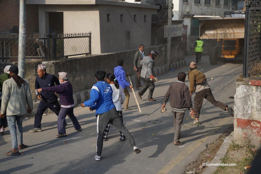 Landless squatters living in a slum area in Thapathali of Kathmandu throw stones at a dozer heading towards the settlement to demolish their huts, on Monday, November 28, 2022. Photo: Chandra Bahadur Ale