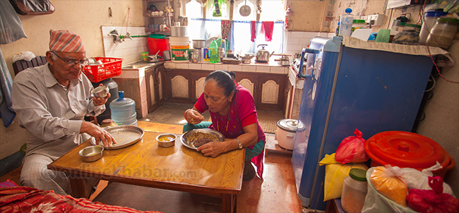 File Photo: Chitra Bahadur Kc having lunch with his wife, at his home in Ghattekulo. 