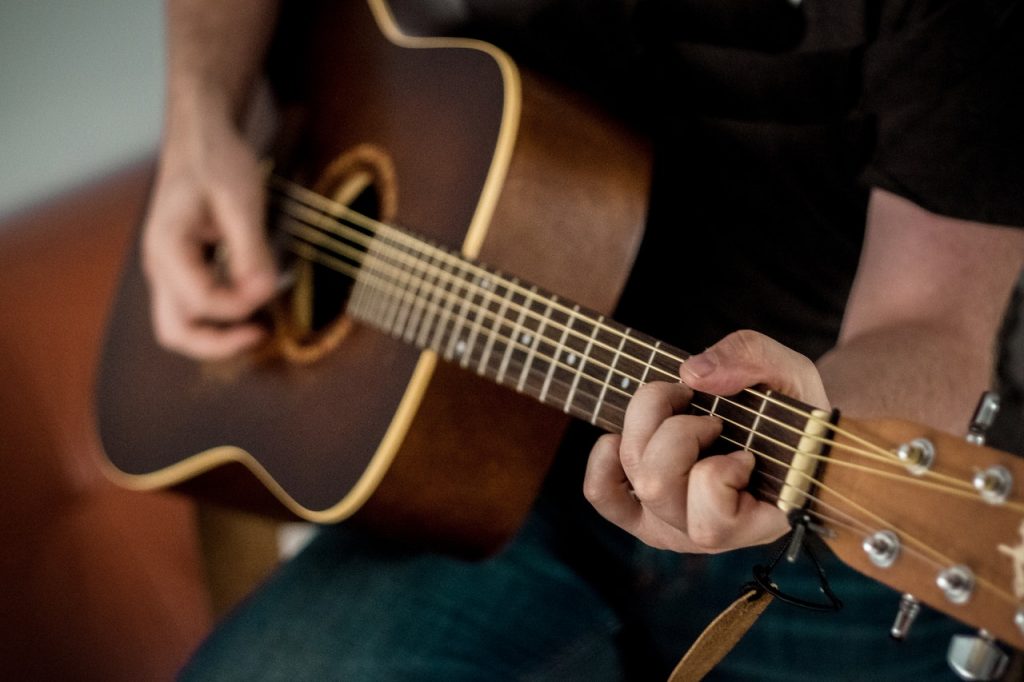 person playing guitar hobbies for all ages