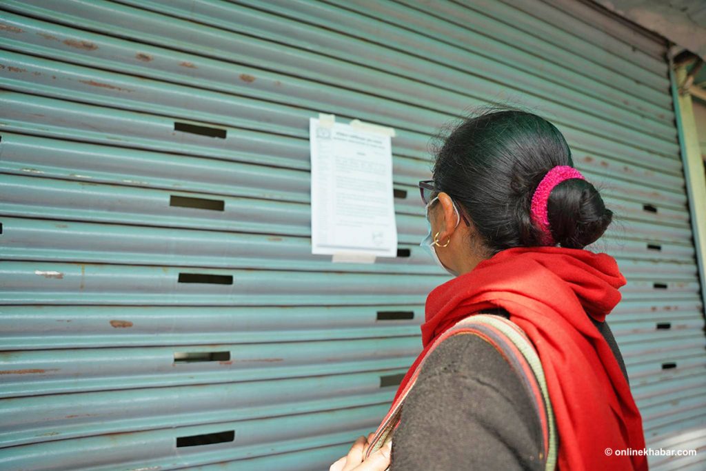 A woman reads a notice about the closure of regular health services on the shutter at Bir Hospital during the doctors' strike, on Sunday, February 12, 2023. Photo: Aryan Dhimal