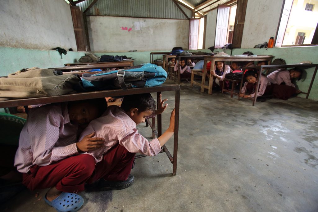 Students of Jana Bikash Secondary School, in Matatirtha practice earthquake drill for which children are taught how to take shelter underneath their desks in case of an earthquake. Photo: Flick/ Jim Holmes for AusAID via Department of Foreign Affairs and Trade