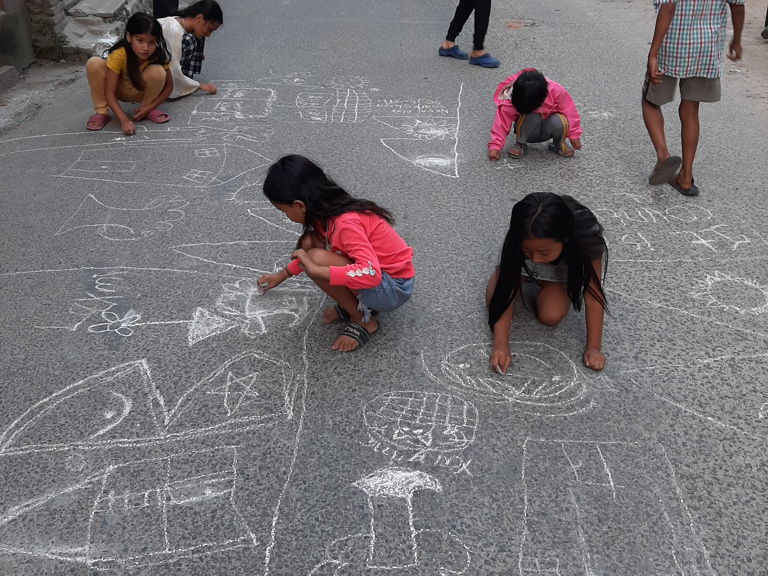 Children drawing their art on the road on car-free Saturdays in Handigaon. Photo Courtesy: Niharika Mathema